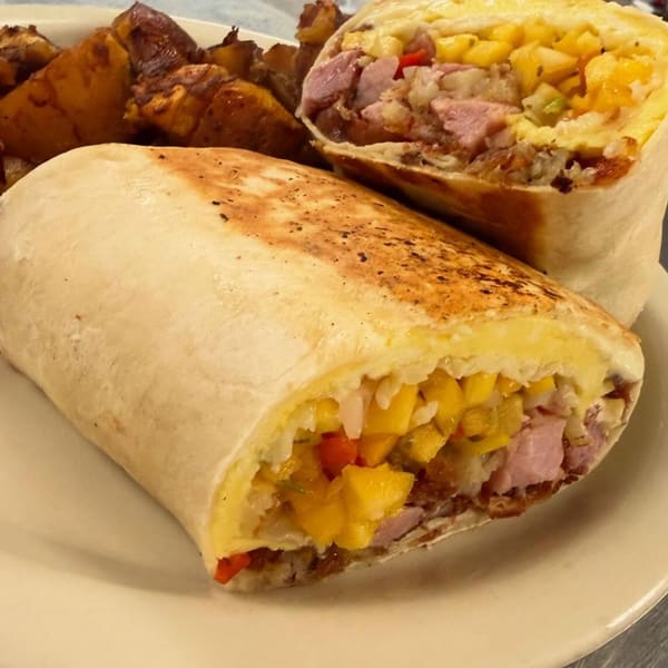 A grilled breakfast burrito cut in half