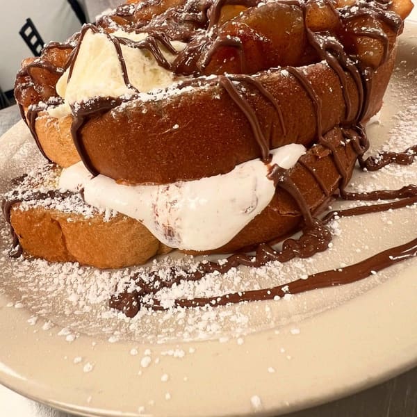Stacked french toast with apples, cream and a chocolate drizzle
